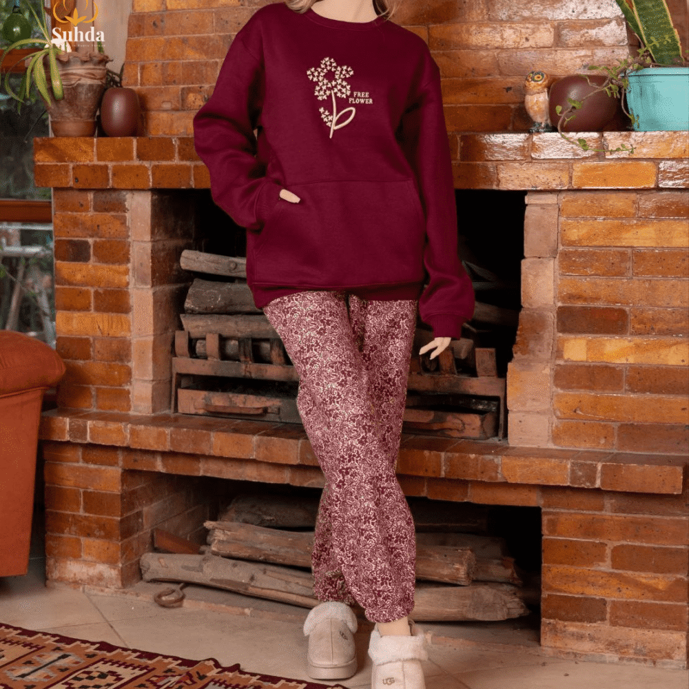 طقم شتوي نسائي بلون عودي يضم جاكت بجيب أمامي وبنطال منقوش، مناسب للارتداء داخل المنزل.