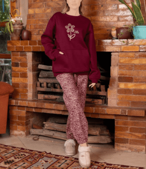 طقم شتوي نسائي بلون عودي يضم جاكت بجيب أمامي وبنطال منقوش، مناسب للارتداء داخل المنزل.