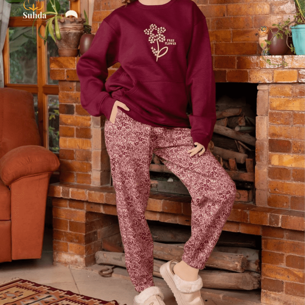 طقم شتوي نسائي بلون عودي يضم جاكت بجيب أمامي وبنطال منقوش، مناسب للارتداء داخل المنزل.