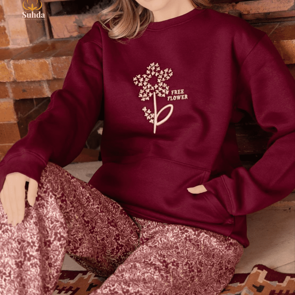 طقم شتوي نسائي بلون عودي يضم جاكت بجيب أمامي وبنطال منقوش، مناسب للارتداء داخل المنزل.