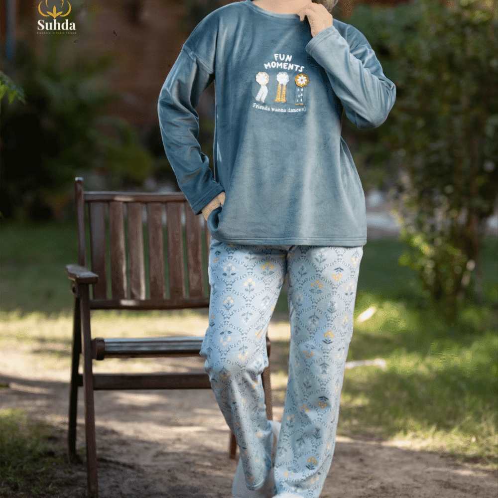 طقم شتوي نسائي يتكون من بلوزة مخملية سماوية اللون مع طبعة أمامية وبنطال منقوش فاتح.