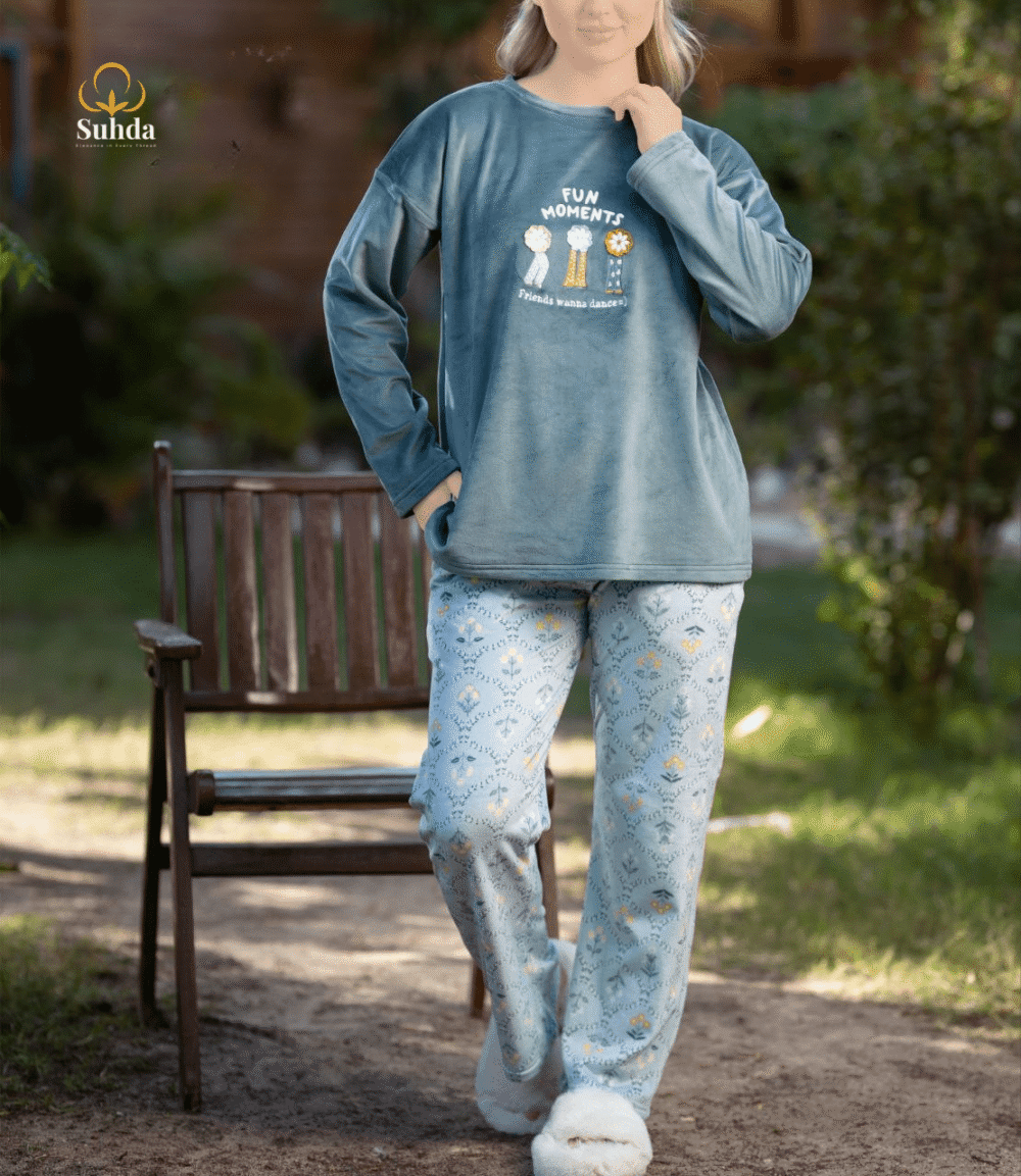 طقم شتوي نسائي يتكون من بلوزة مخملية سماوية اللون مع طبعة أمامية وبنطال منقوش فاتح.