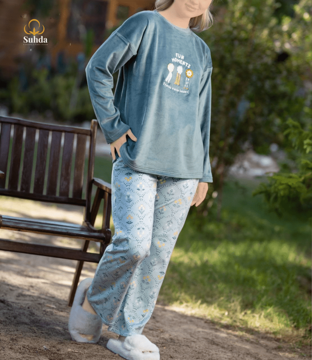 طقم شتوي نسائي يتكون من بلوزة مخملية سماوية اللون مع طبعة أمامية وبنطال منقوش فاتح.