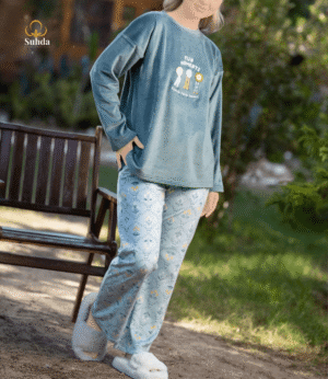 طقم شتوي نسائي يتكون من بلوزة مخملية سماوية اللون مع طبعة أمامية وبنطال منقوش فاتح.