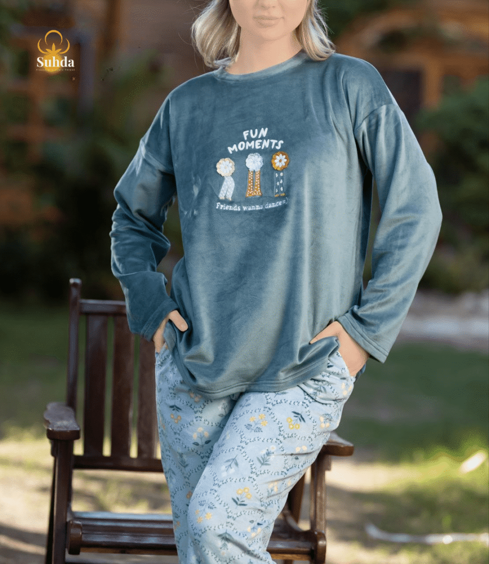 طقم شتوي نسائي يتكون من بلوزة مخملية سماوية اللون مع طبعة أمامية وبنطال منقوش فاتح.