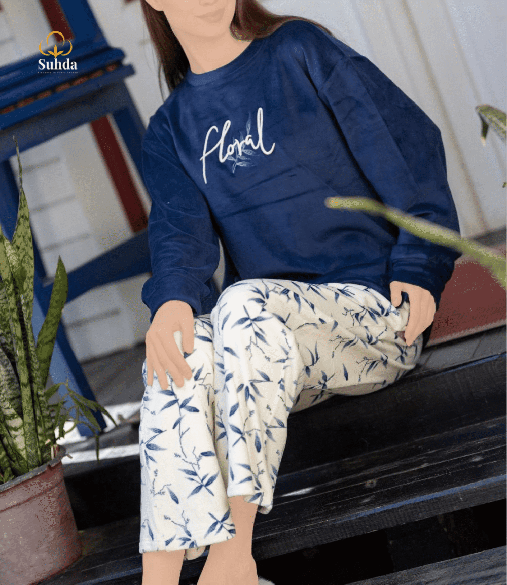 طقم شتوي نسائي بلوزة مخمل سماوية اللون مع بنطال كريمي بنقشة أوراق زرقاء.