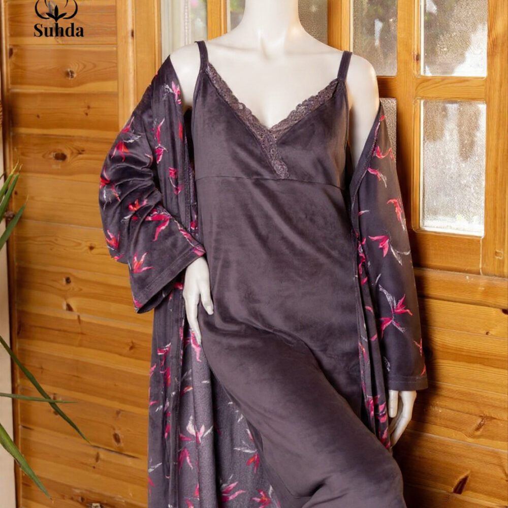 طقم نوم نسائي مخملي بلون بنفسجي داكن يتكون من فستان كت طويل وروب مطبوع بنقشة أوراق وردية.