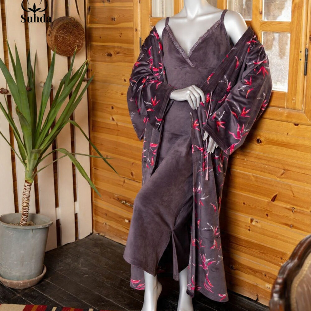 طقم نوم نسائي مخملي بلون بنفسجي داكن يتكون من فستان كت طويل وروب مطبوع بنقشة أوراق وردية.