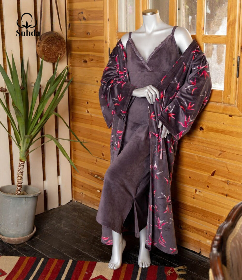 طقم نوم نسائي مخملي بلون بنفسجي داكن يتكون من فستان كت طويل وروب مطبوع بنقشة أوراق وردية.