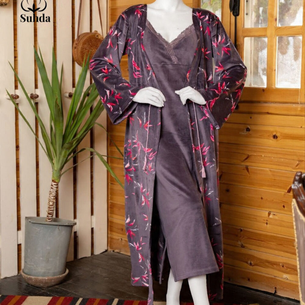 طقم نوم نسائي مخملي بلون بنفسجي داكن يتكون من فستان كت طويل وروب مطبوع بنقشة أوراق وردية.